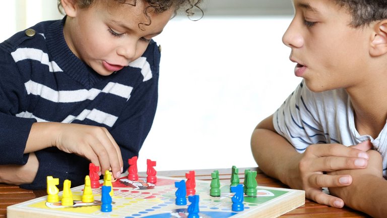 two kids playing board game  Image of two kids playing board game
